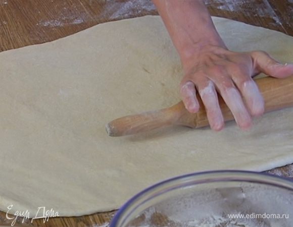 Рабочую поверхность присыпать оставшейся мукой и раскатать подошедшее тесто в пласт толщиной не более 1 см.