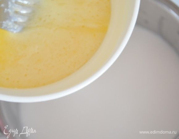 Когда молоко станет горячим, влить тонкой струйкой в него желтки, при этом постоянно помешивая молоко деревянной лопаткой.