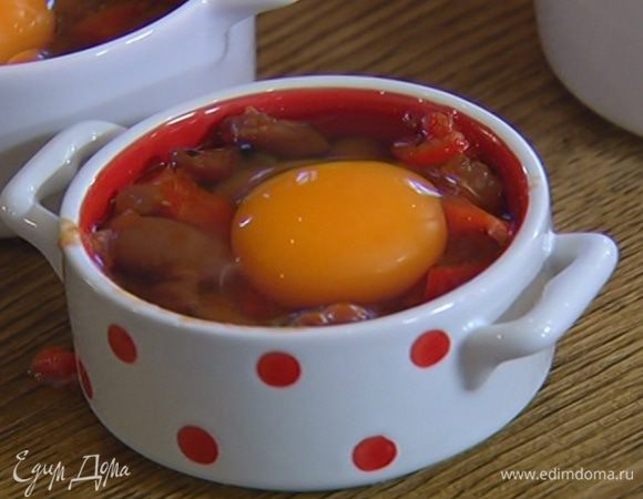 Фасоль с перцем и луком разложить в небольшие керамические формочки, заполняя их на 2/3 объема, затем разбить в каждую по яйцу.