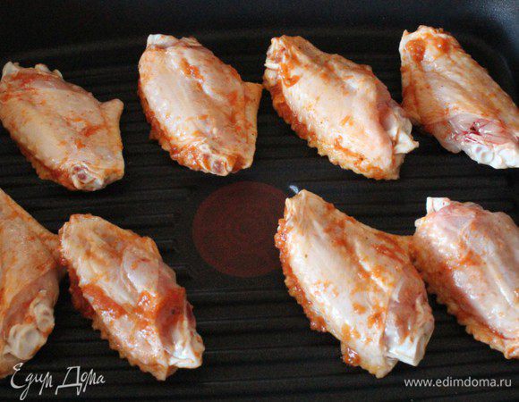 Отряхнуть маринад с крыльев и разложить их на решетке. Жарить над горячими углями по 5 мин. с каждой стороны, до готовности.  Это идеальный вариант... НО... не менее вкусные крылышки получаются, если их жарить на сковороде-гриль. 