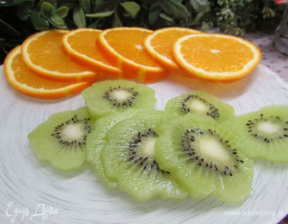Апельсин и киви хорошо вымыть в тёплой воде, обсушить. Киви почистить и нарезать кружочками. Апельсин не чистить, порезать кружочками.