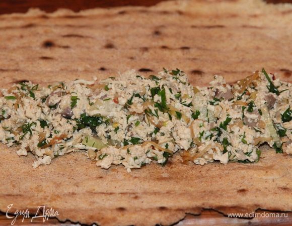 Лепешки отдохнули и стали мягкими. Выкладываем начинку с одного края лепешки и сворачиваем плотно рулет.