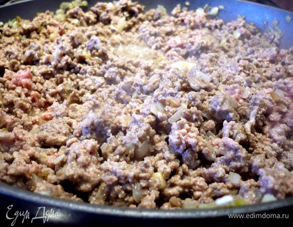 Лук очистим и порежем мелко. В сковороде разогреем оливковое масло и поджарим лук до прозрачности. Добавим фарш и, помешивая, прожарим его практически до готовности. Посолим и поперчим. Пассеруем томаты.