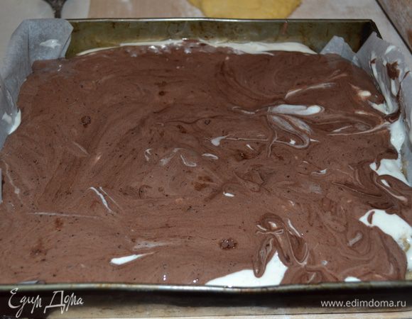 Далее на яблочный слой выкладываем белое тесто, на него аккуратно тесто с какао.  Чтобы получить подобие волн, протыкаем в нескольких местах шоколадное тесто вилкой и немного встряхиваем форму с пирогом.