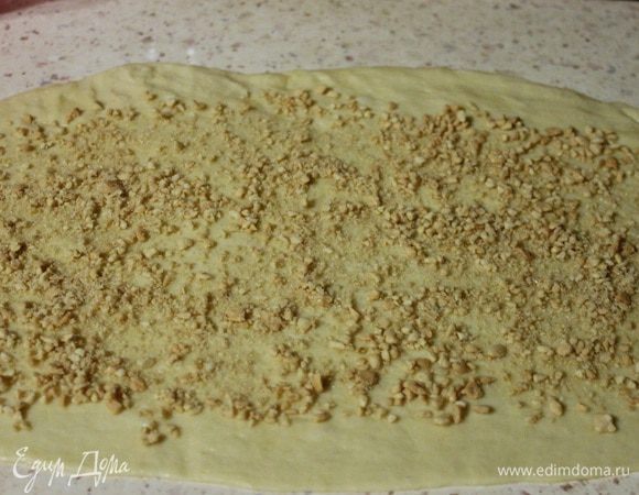 Далее тесто делим на 4 равные части. Раскатываем одну часть в прямоугольник 15х60 см, равномерно распределяем ореховую начинку, скручиваем рулетом защипав в конце края.