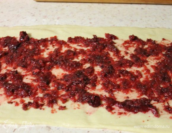 Натретий раскатанный пласт выкладываем начинку из вишни и яблока.