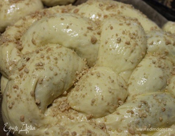 Из полученных рулетов плетем косичку, а потом соединяем концы и получается круглый пирог. Оставляем наш пирог на расстойку, на 15-20 минут. Из оставшегося теста, я сделала просто булочки. Затем верх пирога смазываем взбитым яйцом, посыпаем орешками и отправляем в духовку на 20 минут при температуре 200 градусов. А потом понижаем температуру до 180 градусов и печем еще 25 мину-30 минут.