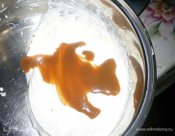 Теперь по столовой ложке добавляем к маслу карамель и каждый раз взбиваем до однородности.