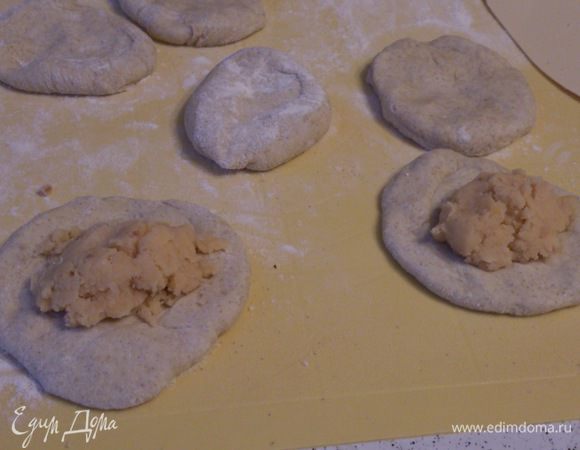 Разделить тесто на небольшие шарики, раскатать их в лепешки и выложить начинку.