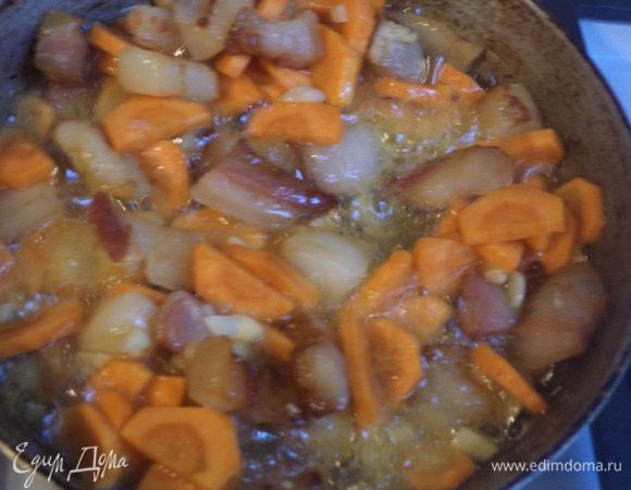 На растительном масле обжарить бекон, добавить морковь и чеснок, обжаривать 3 - 5 минут, до подрумянивания.