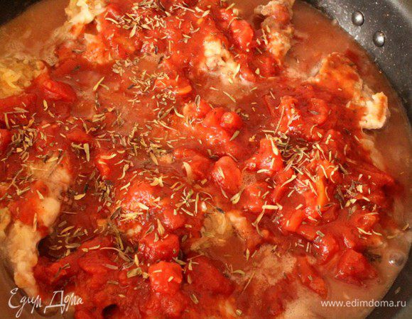 Влить вино, увеличить огонь до максимума и дать вину выпариться на 1/3. Затем добавить рубленные томаты вместе с соком, посыпать молотым орегано, приправить солью и перцем.