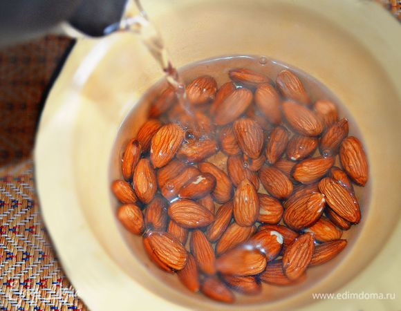 Миндальные орехи залить кипятком, дать постоять 5 мин, затем очистить их от шелухи.