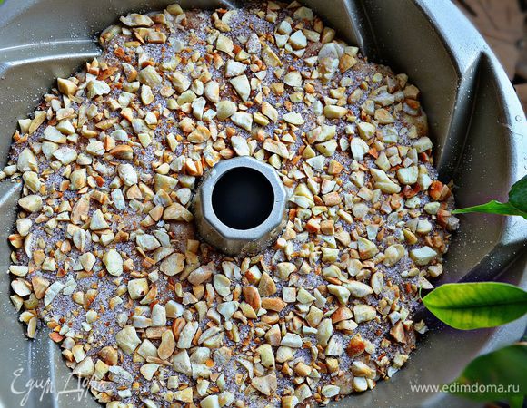 После этого выложите остальное тесто, равномерно распределяя до стенок формы. Сверху посыпьте ореховой смесью, слегка придавливая орехи в тесто.