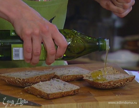 Булочки разрезать вдоль пополам и сбрызнуть половиной оливкового масла.