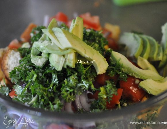 Смешать сухарики с зеленью с 1 го шага. Добавить порезанные овощи и очищенный и порезанный авокадо, перемешать.
