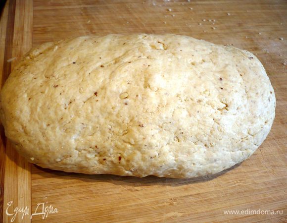 Миндаль для украшения бланшируем в течение нескольких минут, сливаем воду, освобождаем от кожицы и делим вдоль на две равные части. Все ингредиенты для теста смешать до однородности, при этом муку смешать с разрыхлителем и миндальной крошкой и только потом добавить к остальным ингредиентам. Тесто выложить на присыпанную мукой поверхность.