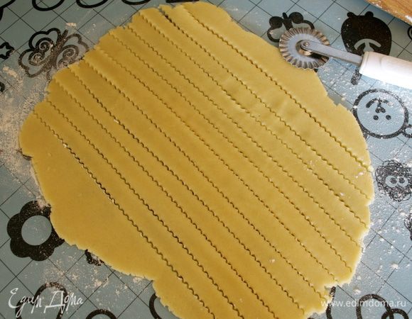 Остатки теста собрать, раскатать из него еще один пласт и нарезать полоски с помощью рельефного ножа...