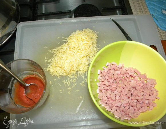 Берём натираем твердый сыр на мел.тёрку, режем мелко колбасу, смешиваем соус со сметаной, туда же кладем чеснок.