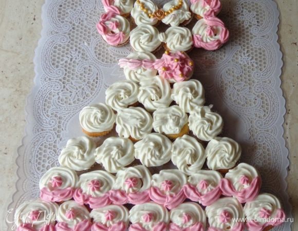 Сложить платье и украсить его кремом и сахарными шариками. 
Девчатам понравится!