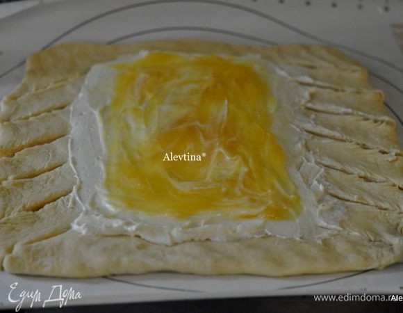 Раскатаем тесто в прямоугольную форму. Выложим половину начинки на середину раскатанного теста из сливочного сыра, сверху лимонный курд, края разрежем острым ножом на одинакового размера полоски.
