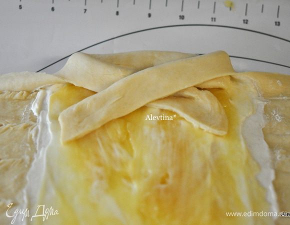 Сплетем косу из этих полосок ,чередуя. Затем также повторим со вторым куском теста. Переложим на противень осторожно.
