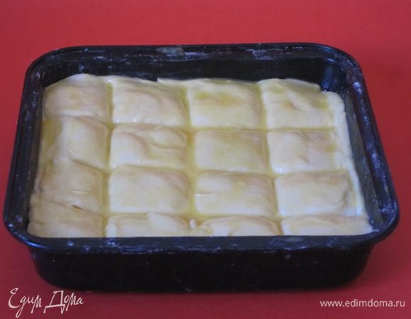 Верхний пласт теста смазать яичным желтком. Разрезать пирог на квадратики.