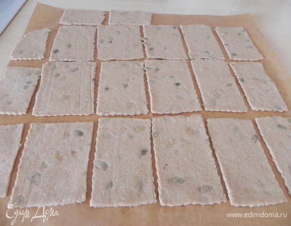 Тонко раскатайте тесто на листе пергамента. Разрежьте на прямоугольники.
