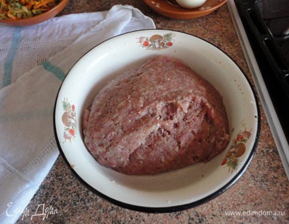 Хлеб замочить в молоке.
4 яйца залить холодной водой и поставить на огонь. Довести до кипения и продолжить варить при умеренном кипении в течение 10 минут.
Одну головку лука нашинковать полукольцами, морковь натереть на крупной терке. Масло хорошо разогреть в сковороде и обжарить в нем вначале лук до слегка золотистого цвета, затем добавить морковь и еще пожарить минуты три. Оставить остывать. Добавить мелко нарезанные зеленый лук и укроп или только укроп.
Лук нарезать мелкими кубиками или пропустить через мясорубку. Все соединить с фаршем, вбить яйцо и белок (желток оставить для смазывания), посолить, поперчить. Хорошо вымешать и тщательно отбить.
