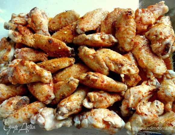 Сложить обжаренные крылышки в жаропрочную форму. Посолить, посыпать молотым перцем чили (от 1 до 1,5 чайных ложек в зависимости от степени остроты) и паприкой.