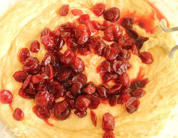 Соединить опару и масляно-яичную смесь. Небольшими порциями добавить просеянную муку. Добавить клюкву вместе с алкоголем. 