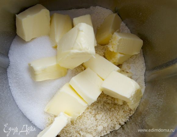 Приготовим тесто. В чашу миксера просеять муку, добавить сахар, миндальную муку и охлажденное сливочное масло кусочками. 