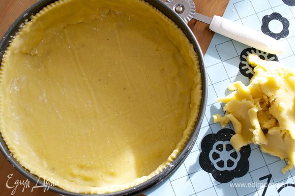 Перенести и выложить тесто в форму для выпечки. Излишки теста обрезать и подровнять край основания пирога.