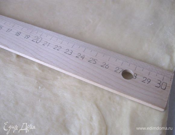 Присыпать рабочую поверхность мукой. Выложить тесто, присыпать сверху мукой. Раскатать в пласт 30 Х 40 см. 
