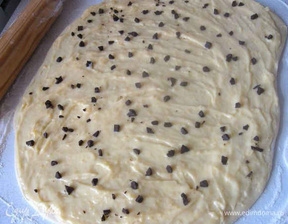 Шоколад порезать на небольшие кусочки. Смазать тесто кремом и  посыпать кусочками шоколада. 