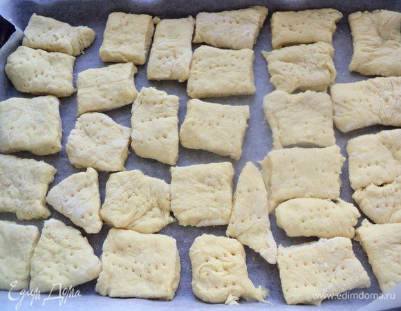 Раскатать тесто в пласт толщиной в палец и разрезать на квадраты. Выложить на противень, наколоть вилкой. 