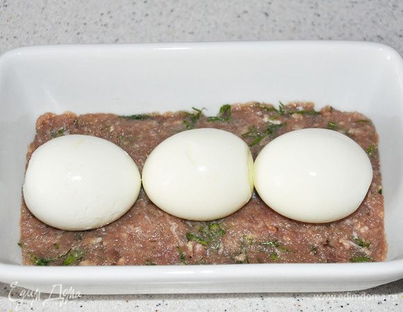 Яйца сварить (минут 7). Выложить треть фарша в форму, выложить яйца.