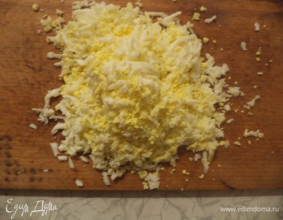 Яйца очистить, натереть на крупной тёрке.
Крабовые палочки и твёрдый сыр тоже натереть на крупной тёрке.
Охлаждённое сливочное масло натереть на тёрке со средними отверстиями. Натёртое сливочное масло сразу же убрать в холодильник.
