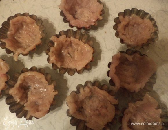 Формочки для кексов (я взяла формочки самого большого размера) смазать растительным маслом, выложить в формочки куриные отбивные, посолить и поперчить их.