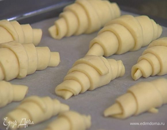Каждый треугольник скатать в рогалик (от широкой части к узкой) и выложить на противень. Накрыть влажным полотенцем и оставить на некоторое время в теплом месте.