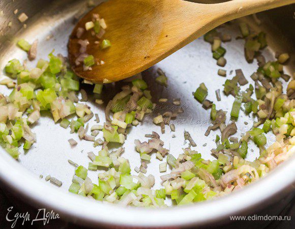 В кастрюле с толстым дном разогреваем оливковое масло. Кладем овощи и прогреваем их 2-3 минуты помешивая, до прозрачности лука. 