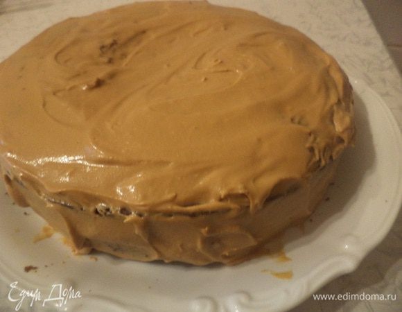 Намазать коржи кремом, обмазать остатками крема бока торта.