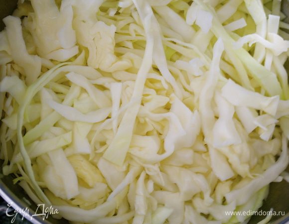 Приготовим гарнир из капусты. Нашинковать капусту. В большой сковороде разогреть 60 г сливочного масла и положить капусту. Перемешать, чтобы она как следует покрылась маслом.  