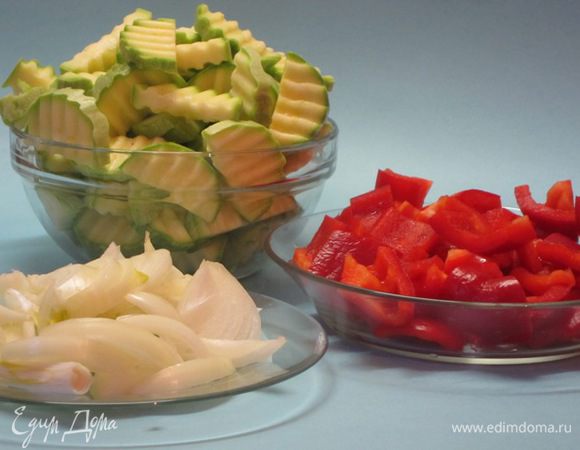 Овощи вымыть. Кабачок нарезать полукружками фигурным ножом. Из перца удалить сердцевину, крупно нарезать. Лук нарезать соломкой.