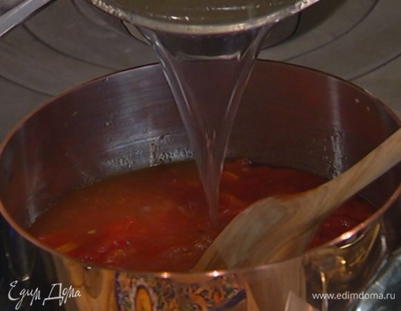 Измельченные специи и помидоры в собственном соку выложить в кастрюлю с чесноком, немного прогреть, затем добавить сладкий перец и помидор и залить все горячим бульоном и довести до кипения.