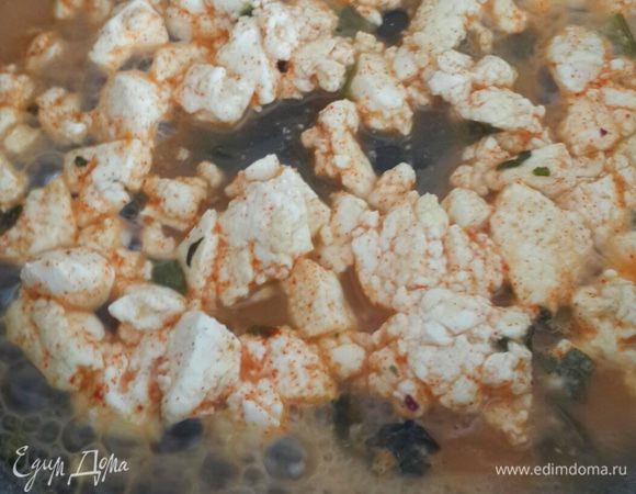 Добавляем специи. Сыр должен кипеть и стать как плавленный. Из него выделится жидкость.