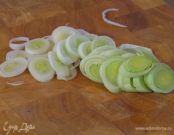 Светлую часть лука-порея нарезать кольцами.
