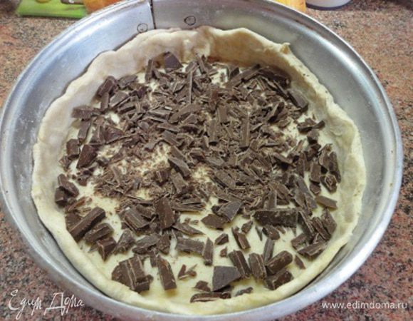 Яйцо и желток, соединить с сахаром, ванилином и сливками и взбить миксером.
Тестом выложить дно формы для запекания (26  см), сформировав бортики. На дно высыпать кусочки шоколада, 