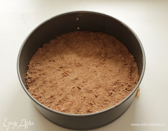 На бумагу для выпечки в разъемную форму  диаметром 20 см выложите 2/3 крошки  и слегка прижмите. 