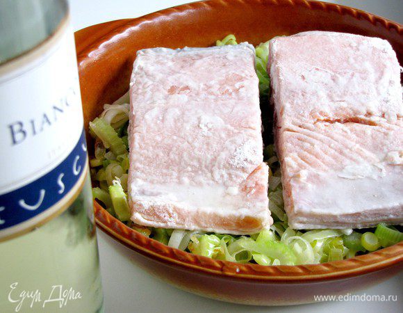 Выложить обжаренные овощи в неглубокую форму для запекания. Сверху поместить филе рыбы. Полить белым сухим вином