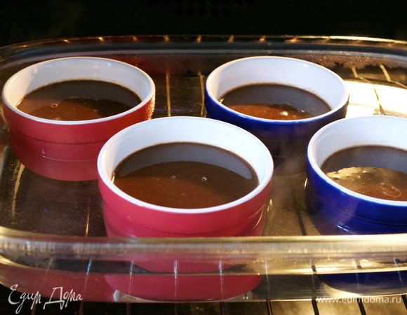 Разлить полученную смесь по креманкам, приблизительно 125 мл в каждую... Поставить креманки в глубокую форму с высокими бортами и осторожно наполнить форму горячей водой, на 2/3 высоты формочек. Поставить в духовку. Запекать от 40 минут до 1 часа (зависит от Вашей духовки). Формочки с готовым крем-брюле остудить и поставить в холодильник.